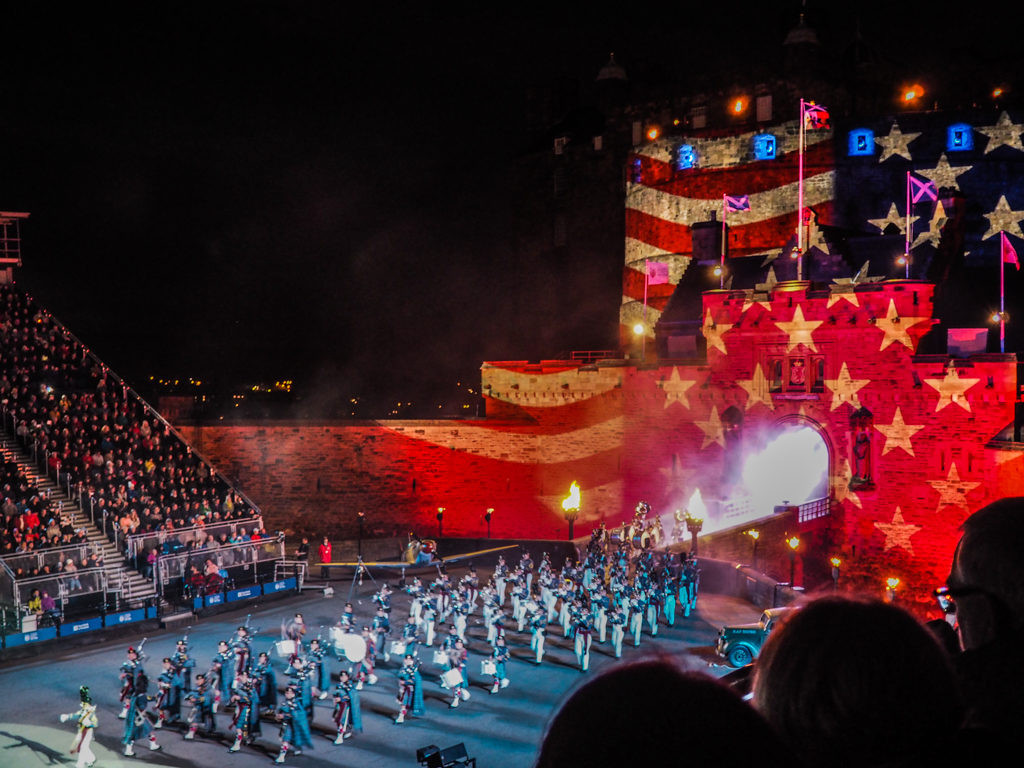 American Military performers and the Edinburgh Castle with the American flag projected on it at the Royal Edinburgh Military Tattoo