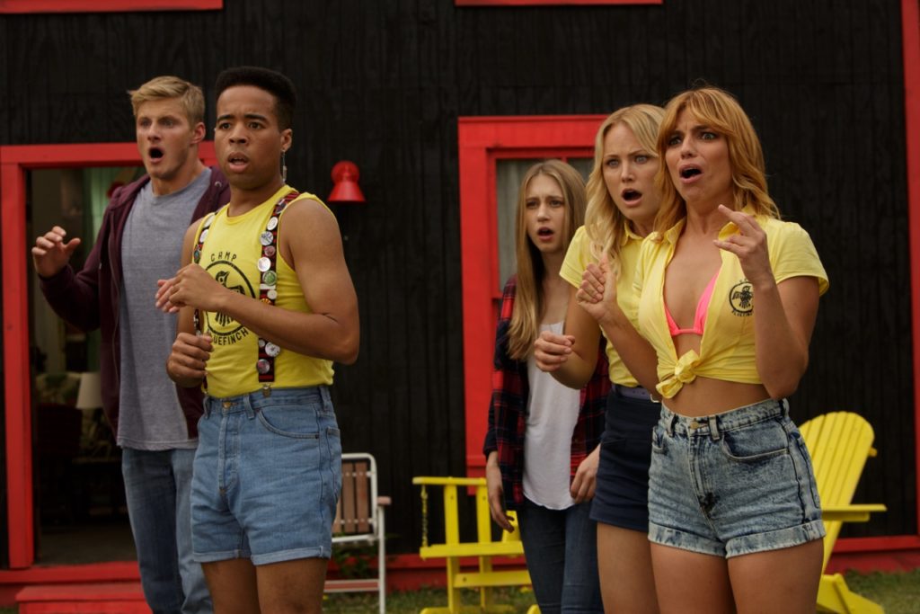 The Final Girls (2015) film still featuring five summer camp counsellors in uniform looking horrified