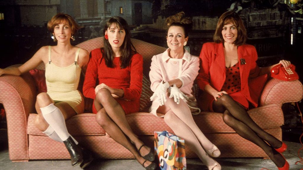 Woman on the Verge of a Nervous Breakdown (1988) film still of four woman cross-legged on a sofa