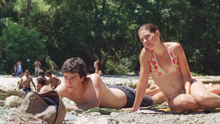 Still of a man and woman relaxing on the beach from the Portuguese movie Our Beloved Month of August (2010)
