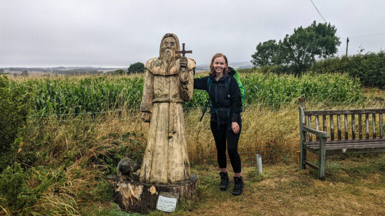 Almost Ginger blog owner posing with wooden St Cuthbert Statue in Northumberland, England